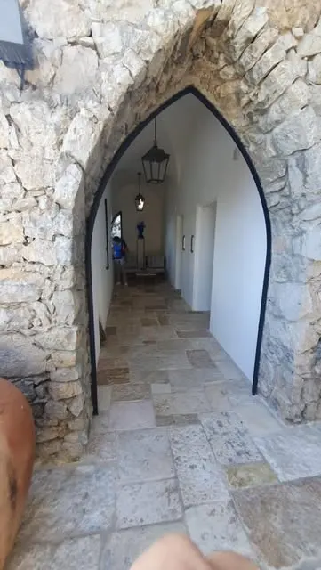 Pavimento in chianca antica che passa da un arco in pietra a un corridoio interno