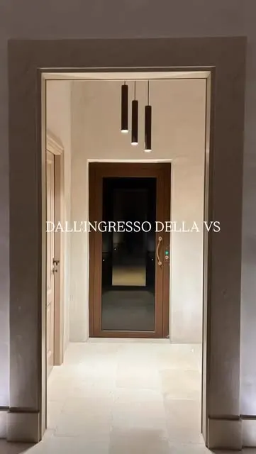 Disimpegno d'ingresso con pavimento in grandi lastre di pietra chiara levigata